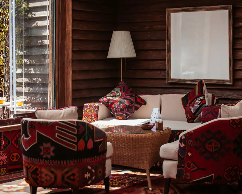 Living area with patterned upholstered armchairs, sofa and cushions